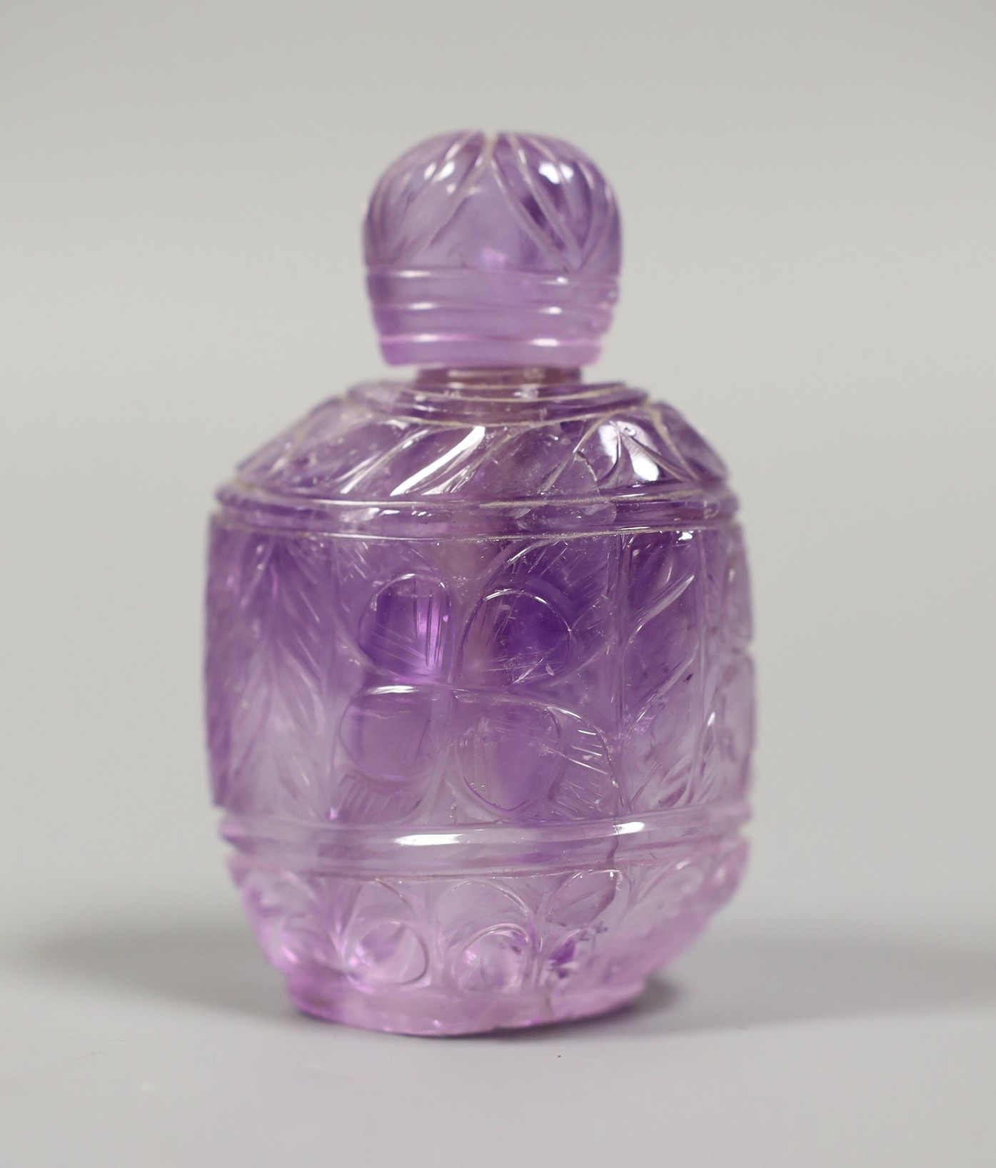 A carved amethyst quartz scent bottle and stopper, 9.5 cms high